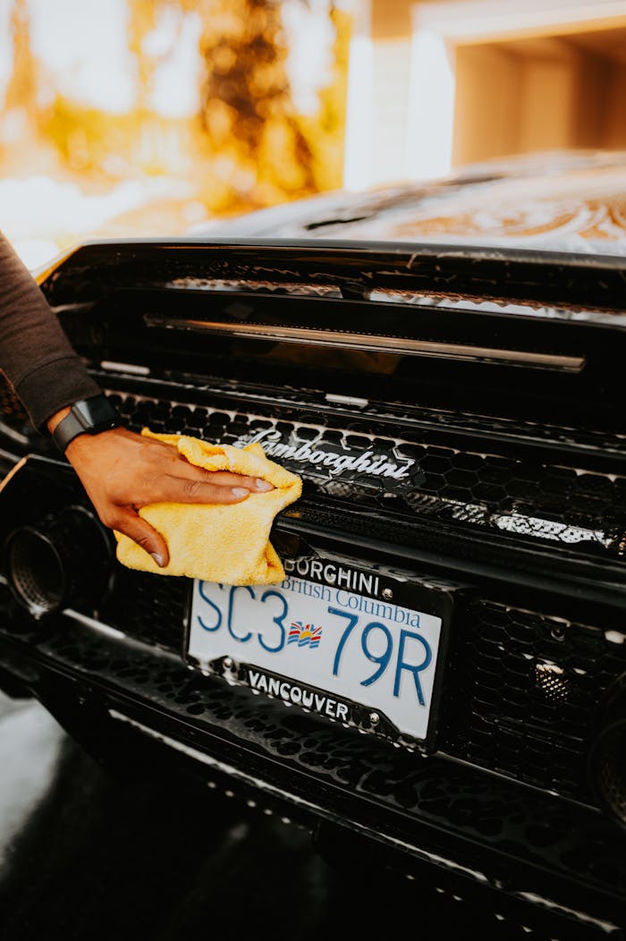 why-choose-us A close-up of a hand cleaning a Lamborghini with a cloth, highlighting luxury car care in Vancouver.